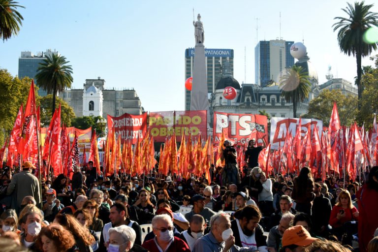 "Acto del Frente de Izquierda. Se puede ver a una gran multitud y de fondo banderas mayoritariamente rojas, amarillas y blancas del PO, MST, Izquierda Socialista y el PTS"